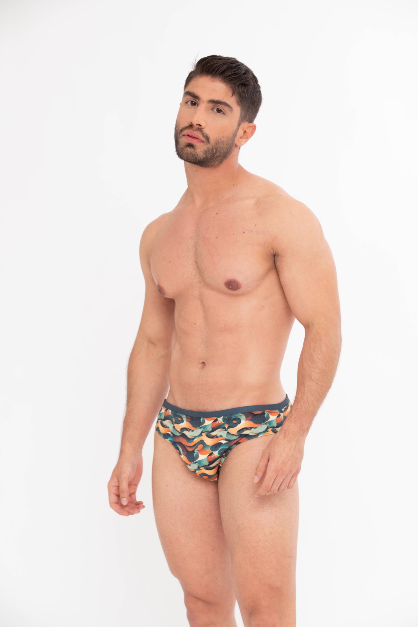 Man wearing a colorful swim brief on a white background. designer swim briefs in classic fit