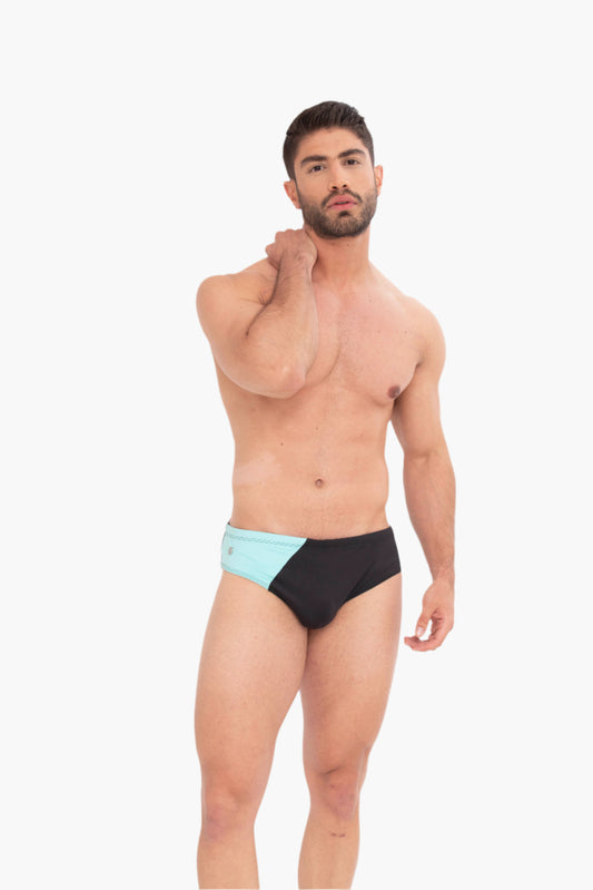 Man wearing black and light blue swim briefs on a white background. inspired by diamond beach in iceland.