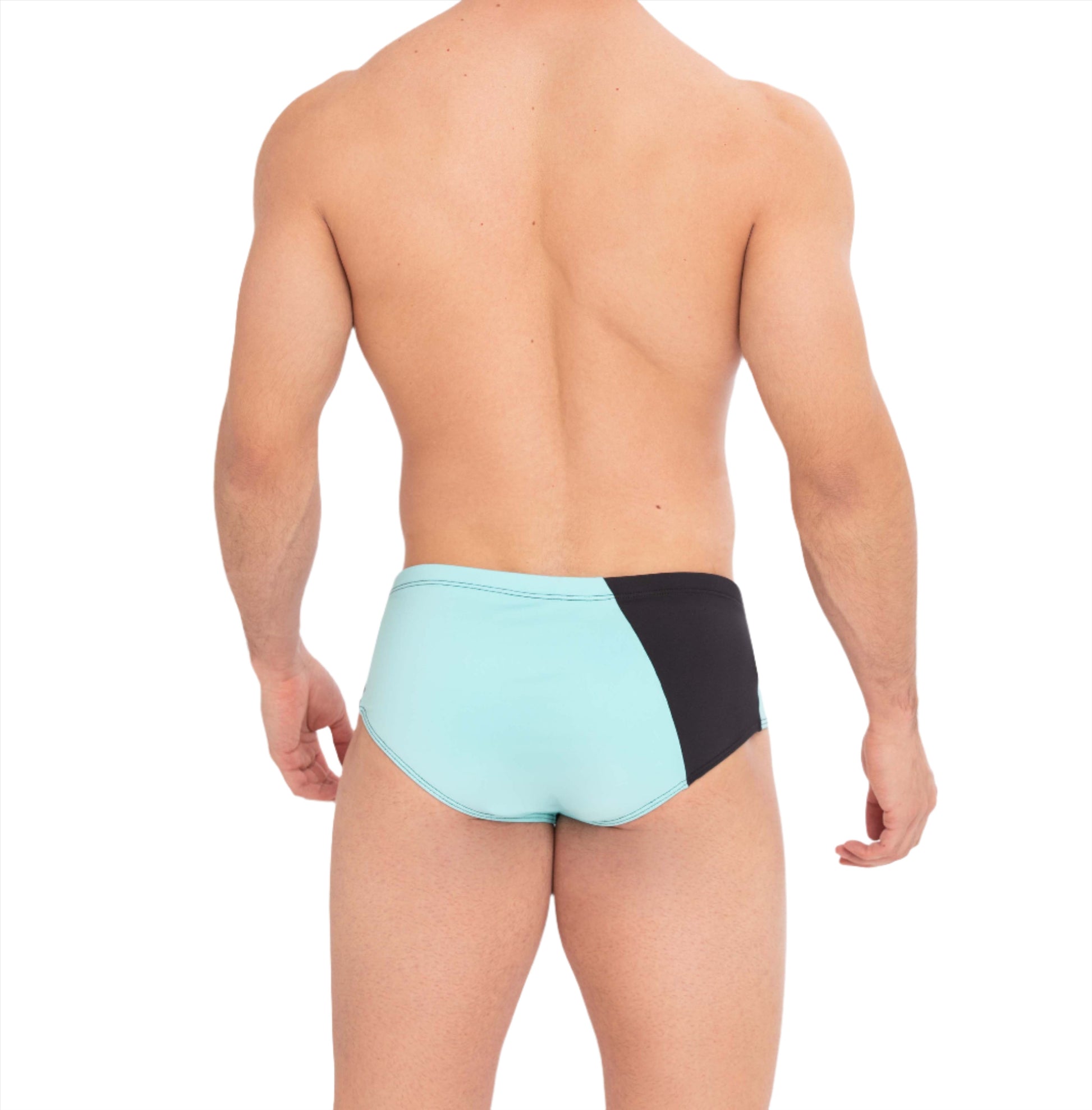 This image features the back view of a male model sporting the Athletic Swim Brief, a stylish hybrid of traditional briefs and sungas. The swimsuit is designed with a striking color block pattern in glacier blue and volcanic black, inspired by the contrasting landscapes of Diamond Beach in Iceland.