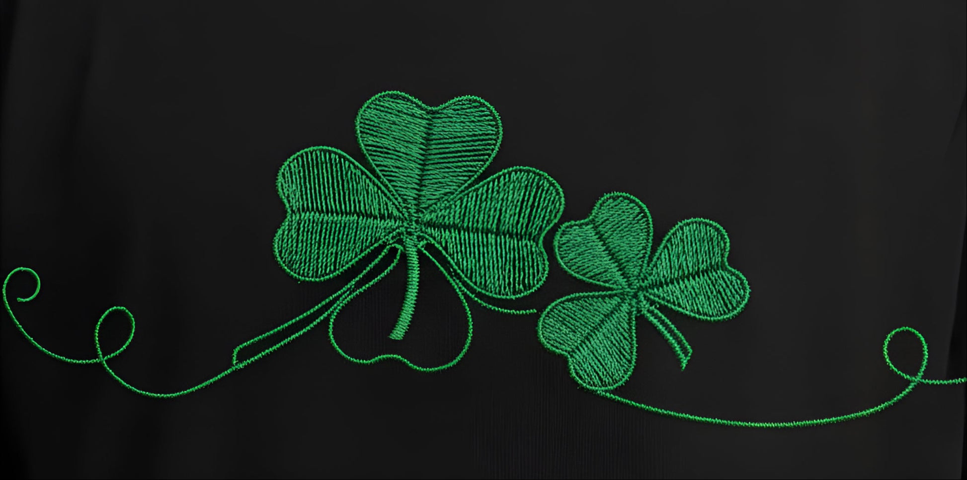Person wearing a black shirt with green shamrock design on a white background